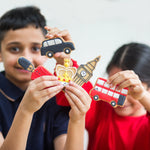 Children holding London-themed cookies: car, bus, guard, crown, and Big Ben.