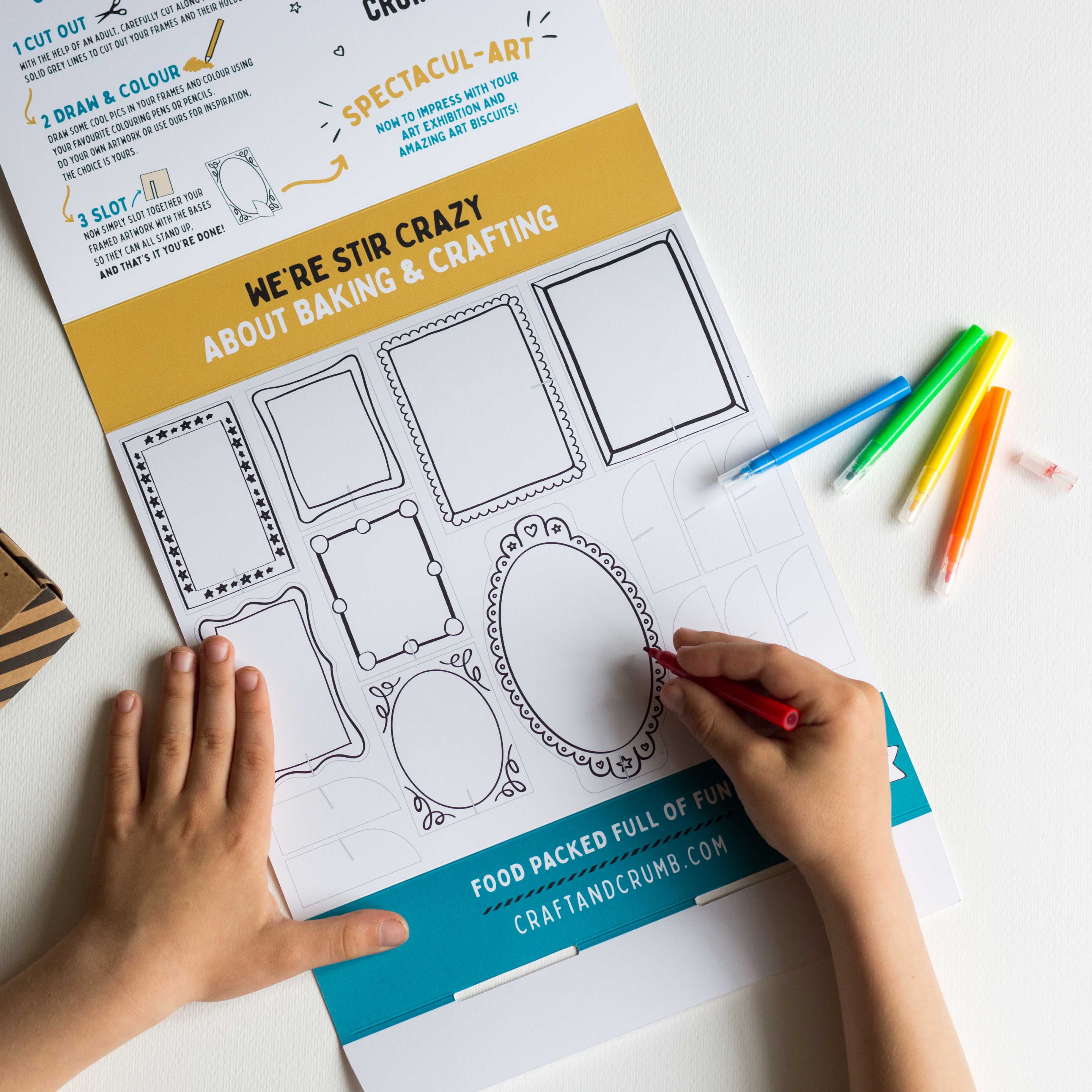Child drawing on a craft sheet with colorful pens, featuring various frame designs for creative activities.