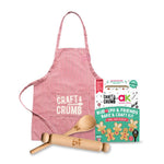 Red striped apron, wooden rolling pin, spoon, and Rudolph & Friends Bake & Craft Kit with gingerbread designs.