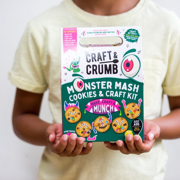 Child holding Craft & Crumb Monster Mash Cookies & Craft Kit, featuring colorful monster-themed cookies, ideal for kids' baking and crafting activities in the UK.