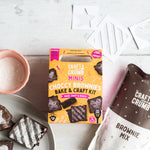 Craft & Crumb Minis Choccy Brownies Bake & Craft Kit on a table with brownies and crafting materials.