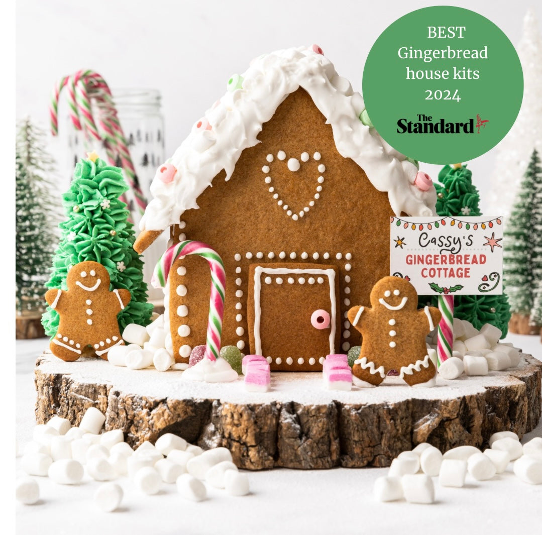 Gingerbread house with candy decorations, gingerbread figures, and a sign reading "Cassy's Gingerbread Cottage."
