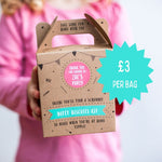 Child holding a brown box with "Dotty Biscuits Kit" and a teal starburst showing "£3 per bag" in pink and teal text.