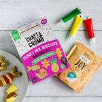 Craft & Crumb Funky Mix Biscuits Baking Kit with colorful icing tubes and decorated cookies on a white wooden surface.